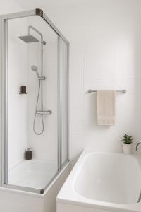 a white bathroom with a shower and a tub at Family & Friends Residence in Koblenz