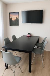 a black dining room table with chairs and a flat screen tv at Family & Friends Residence in Koblenz