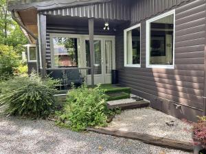 a porch of a house with a door and some plants at Chalet Siesta 3 chambres avec visite virtuelle disponible à la demande in Durbuy