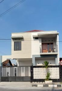 a white house with a black fence at Mentari Homestay in Sentool