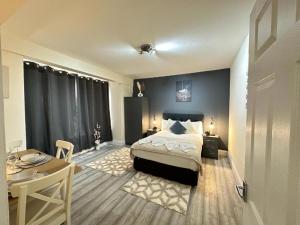 a bedroom with a bed and a table and a desk at Edgware Road Beautiful Family Apartment in London