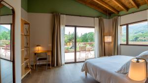 a bedroom with a bed and a large window at Casa Rural La Garza y la Paloma in Navaconcejo