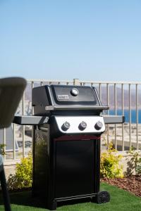 a grill sitting on the grass next to a beach at Villa Dekel - By Harim in Eilat