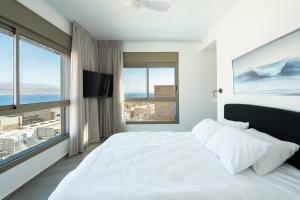 a white bedroom with a large bed and a large window at Villa Dekel - By Harim in Eilat +23 photos