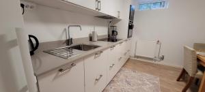 a kitchen with white cabinets and a sink at Modern apartment near Volvo Cars in Torslanda