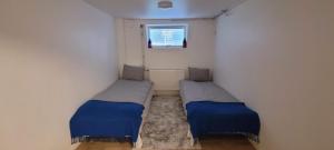 two beds in a small room with a window at Modern apartment near Volvo Cars in Torslanda