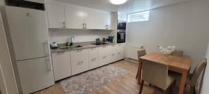 a kitchen with white cabinets and a wooden table and a table and a dining room at Modern apartment near Volvo Cars in Torslanda +14 photos
