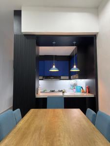 a kitchen with a wooden table and blue chairs at 3A HOMESTAY USTAZ Krai in Kuala Kerai