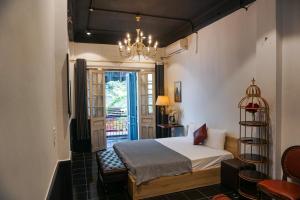 une chambre avec un lit et un lustre dans l'établissement Skylux Hanoi Homestay, à Hanoï