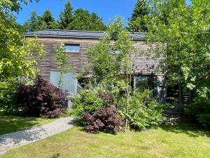 una casa de ladrillo con un jardín delante de ella en The Wurmstein House - Contemporary Mountain Home, en Bad Goisern