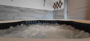 Saint-Michel-TubœufVilla Maëlla en Normandie- chambres tout confort - SPA的壁旁装满水的浴缸