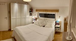 Un dormitorio con una cama blanca y un televisor. en The Wurmstein House - Contemporary Mountain Home, en Bad Goisern
