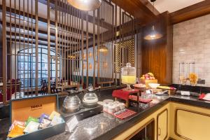 a restaurant with a counter with food on it at SaraSadan Boutique Hotel - Tribhuvan Airport in Kathmandu