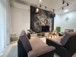 a living room with two couches and a flat screen tv at Bukit Indah Homestay in Johor Bahru