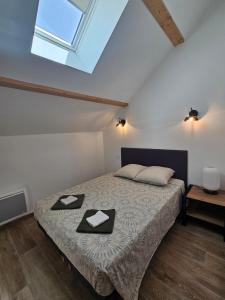 ein Schlafzimmer mit einem Bett, auf dem zwei Handtücher liegen in der Unterkunft Le duplex in Les Angles