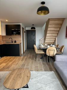 ein Wohnzimmer mit einem Tisch und einer Küche in der Unterkunft Le duplex in Les Angles