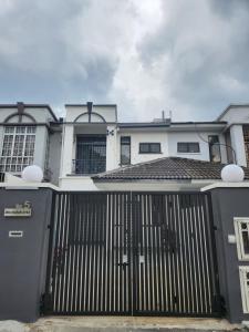 a white house with a gate in front of it at Bukit Indah Homestay in Johor Bahru