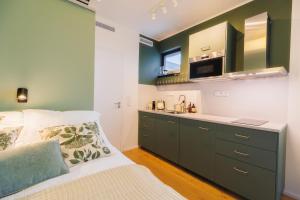 a bedroom with a bed and a sink and a microwave at Tiny Vanguard- Cosy flat with free luxe wellness in Prague +23 photos