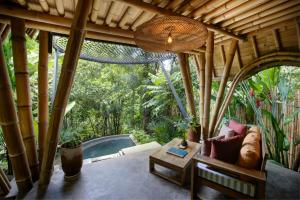 a pavilion with a pool in the middle of a house at Mahajiva in Badung