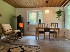 NeubäuにあるFerienhaus am Neubäuer Seeのリビングルーム(テーブル、椅子、薪ストーブ付)