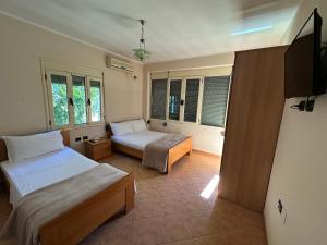 a bedroom with two beds and a tv in it at Hotel Kudhesi in Vlorë