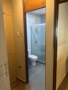 a bathroom with a toilet and a glass shower at Casita en Ica Villa Periodista cerca a Huacachina in Ica