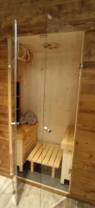 een sauna met een bank en een glazen deur bij Chalet Radola in Campitello di Fassa +4 foto's