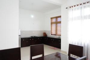 a kitchen with a table and chairs and a window at KelKam Villa Colombo in Maharagama