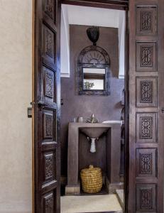 un baño con lavabo y espejo en Riad Maud, en Marrakech