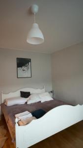 a bedroom with a large white bed with a lamp at Farostrand in Klintehamn