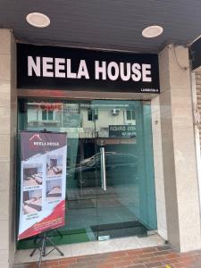 a needala house store with a sign in front of it at Neela House in Labuan