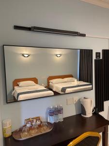 ラブアンにあるNeela Houseのベッドが2つ置かれた机の上の壁に鏡がある +19枚の写真