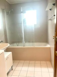 a bathroom with a tub and a sink at Comfortable apartment a stone's throw from Nyon in Duillier +12 photos