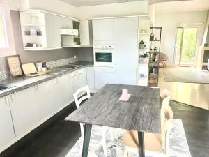 a kitchen with a wooden table and chairs in it at Comfortable apartment a stone's throw from Nyon in Duillier