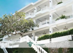 a white building with stairs and a tree at SV Boutique Resort in Vung Tau