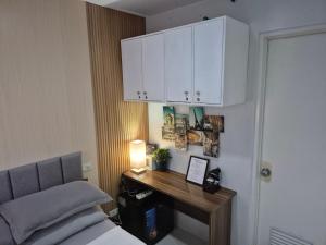 a bedroom with a bed and a desk and white cabinets at 913Cityscape located at city center in Bacolod