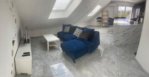 a living room with a blue couch and a table at T3 Nangy in Nangy
