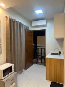 a kitchen with a sink and a microwave on a counter at Casa Leveria Unit 9 with Balcony, Inquire Parking Availability in Imus
