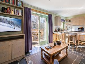 a kitchen and living room with a television and a table at Chalet calme avec terrasse, proche pistes, Méribel - FR-1-565-37 in Les Allues