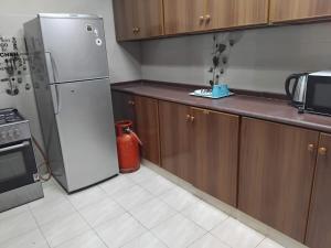 a kitchen with stainless steel appliances and wooden cabinets at MANAZEL ladies and Family stay only corniche in Khor Fakkan +7 photos