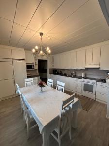 cocina con mesa blanca y armarios blancos en WhiteHouse, peaceful togetherness, en Lehtimäki