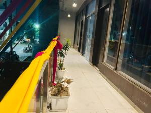Una bufanda amarilla y roja en una barandilla afuera de un edificio en Hotel Urban Nest, en Noida