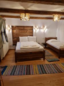 a bedroom with two beds and a rug at Wild-Traditional Bucovina in Câmpulung Moldovenesc