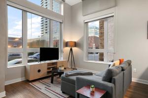 een woonkamer met een bank en een flatscreen-tv bij CozySuites Marquee in Minneapolis