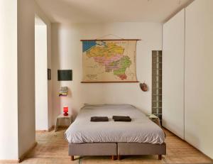 ein Schlafzimmer mit einem Bett mit einer Karte an der Wand in der Unterkunft B'Kanal in Brüssel