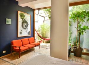 an orange couch in a room with a window at B'Kanal in Brussels