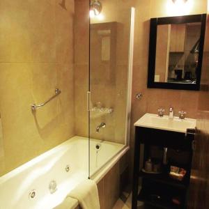 une salle de bain avec une douche, une baignoire et un lavabo dans l'établissement Costa Nahuel Apartments 1, à San Carlos de Bariloche