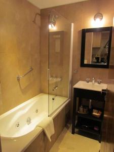 une salle de bain avec une douche, une baignoire et un lavabo dans l'établissement Costa Nahuel Apartments 1, à San Carlos de Bariloche
