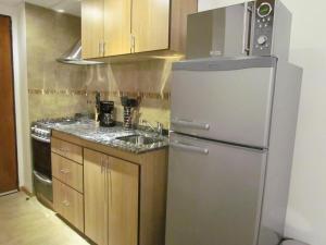 une cuisine avec un réfrigérateur en acier inoxydable et un évier dans l'établissement Costa Nahuel Apartments 1, à San Carlos de Bariloche 10 autres photos