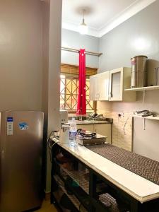 a kitchen with a refrigerator and a counter top at Cozy & comfy in Kira